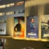 Photo of a Hollywood studio wall covered with television and movie posters advertising a variety of productions.