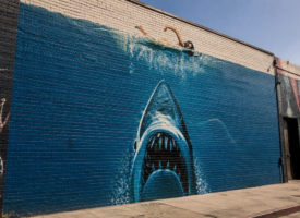 Hand-painted shark mural on a brick wall, inspired by the practical artistry of classic filmmaking.