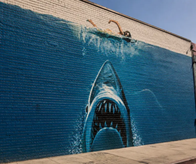 Hand-painted shark mural on a brick wall, inspired by the practical artistry of classic filmmaking.