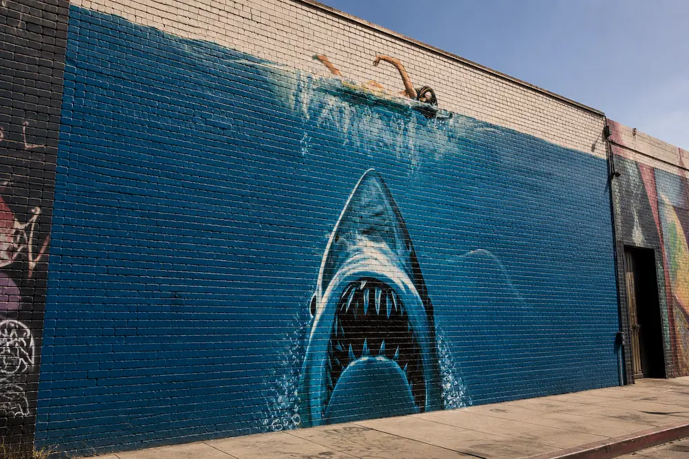 Hand-painted shark mural on a brick wall, inspired by the practical artistry of classic filmmaking