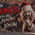 street-art mural of Art the Clown in a Santa hat and wings, with "The Monster You Already Know" spray-painted beside him on a brick wall.